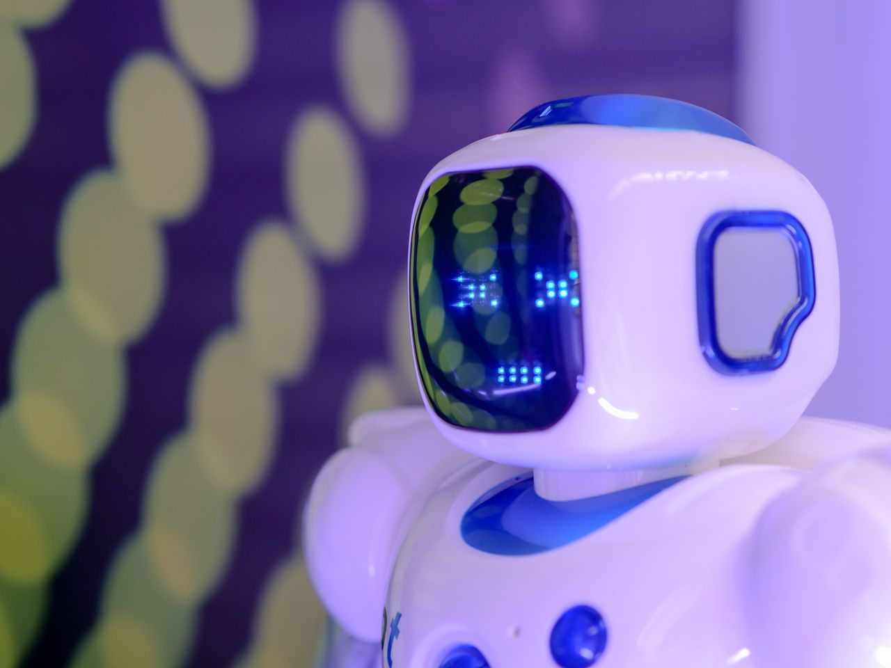 why-choose-us-02 Close-up of a futuristic humanoid robot with a luminescent display in a modern setting.